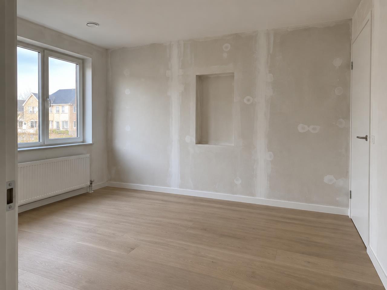 Kale, behangklare wand in een nieuwbouwruimte
